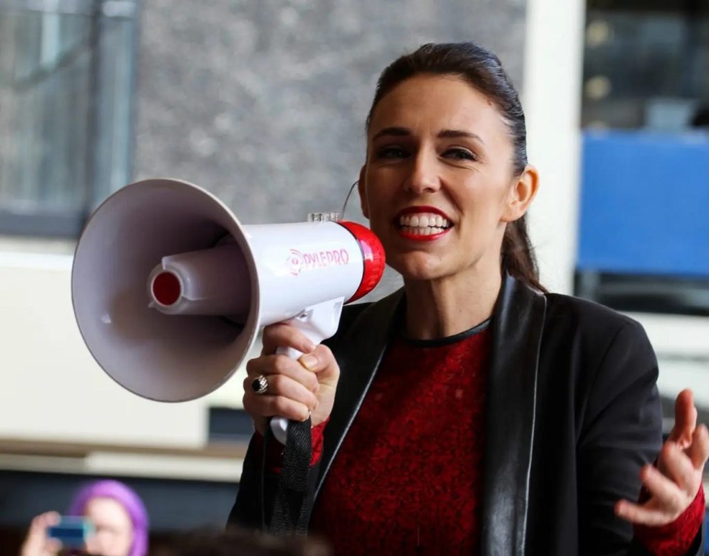 Jacinda Ardern speaking to a crowd using a megaphone scaled